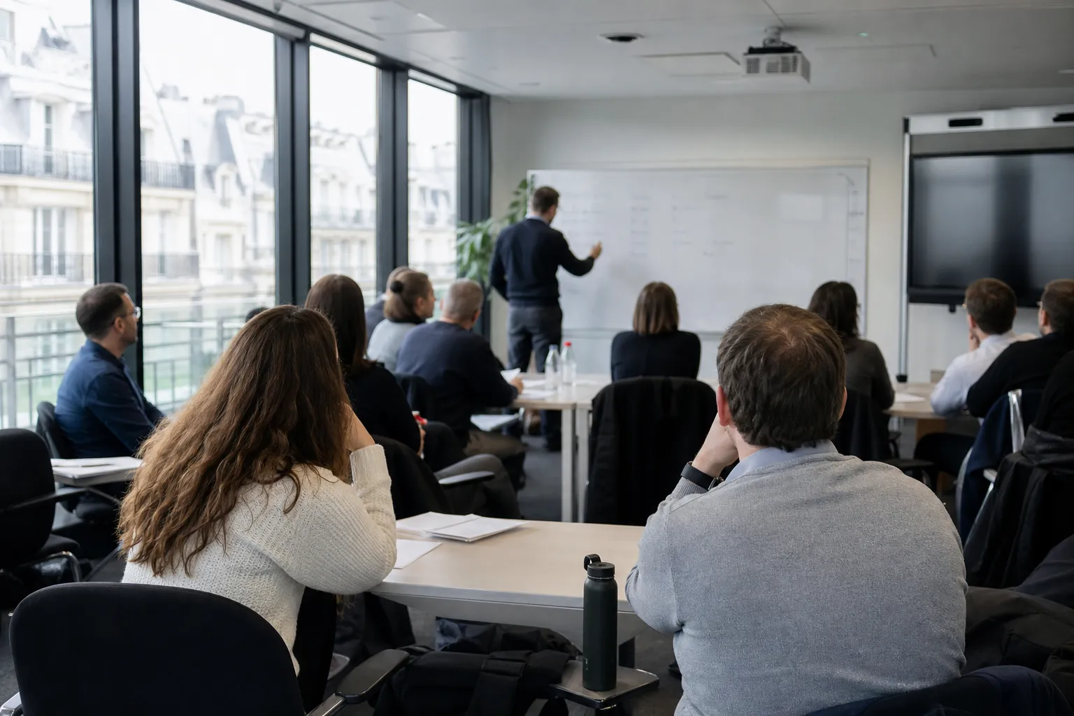 Salle de réunion d’entreprise pendant une session de formation en langue, tableau blanc en arrière-plan